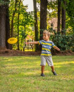Boy throwing frisbee in New Jersey yard.